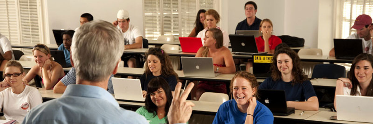 A professor shows a classroom how to make the Pony Ears hand sign.